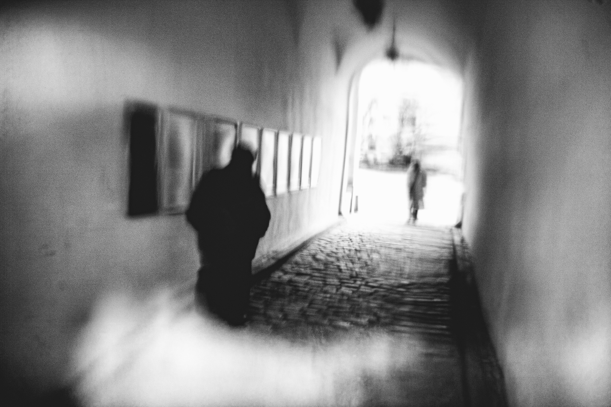 Krzywe Linie Proste - człowiek podążający za kobietą w przejściu na Zamku Królewskim w Szczecinie